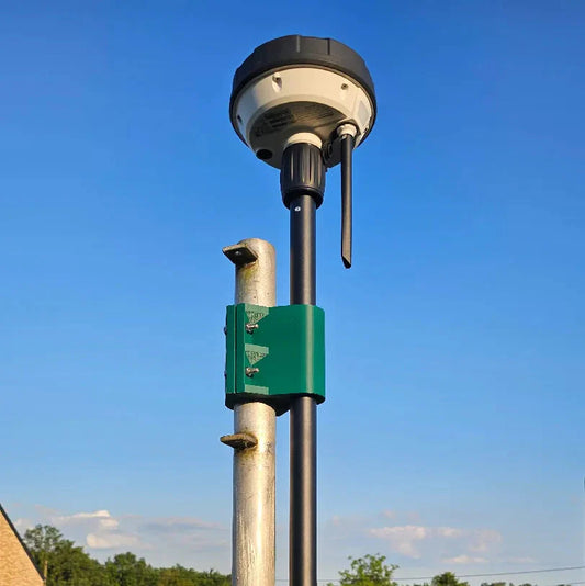 RTK reference station pole rod mounting bracket with a green and black color scheme, attached to a pole against a clear blue sky background.
