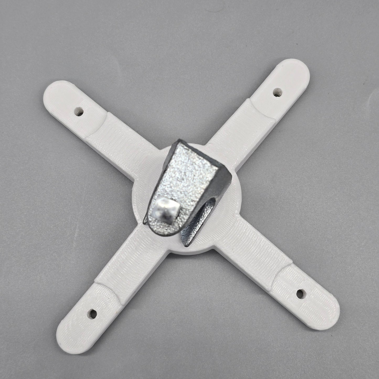 White plastic bracket with a central metallic component on a gray background