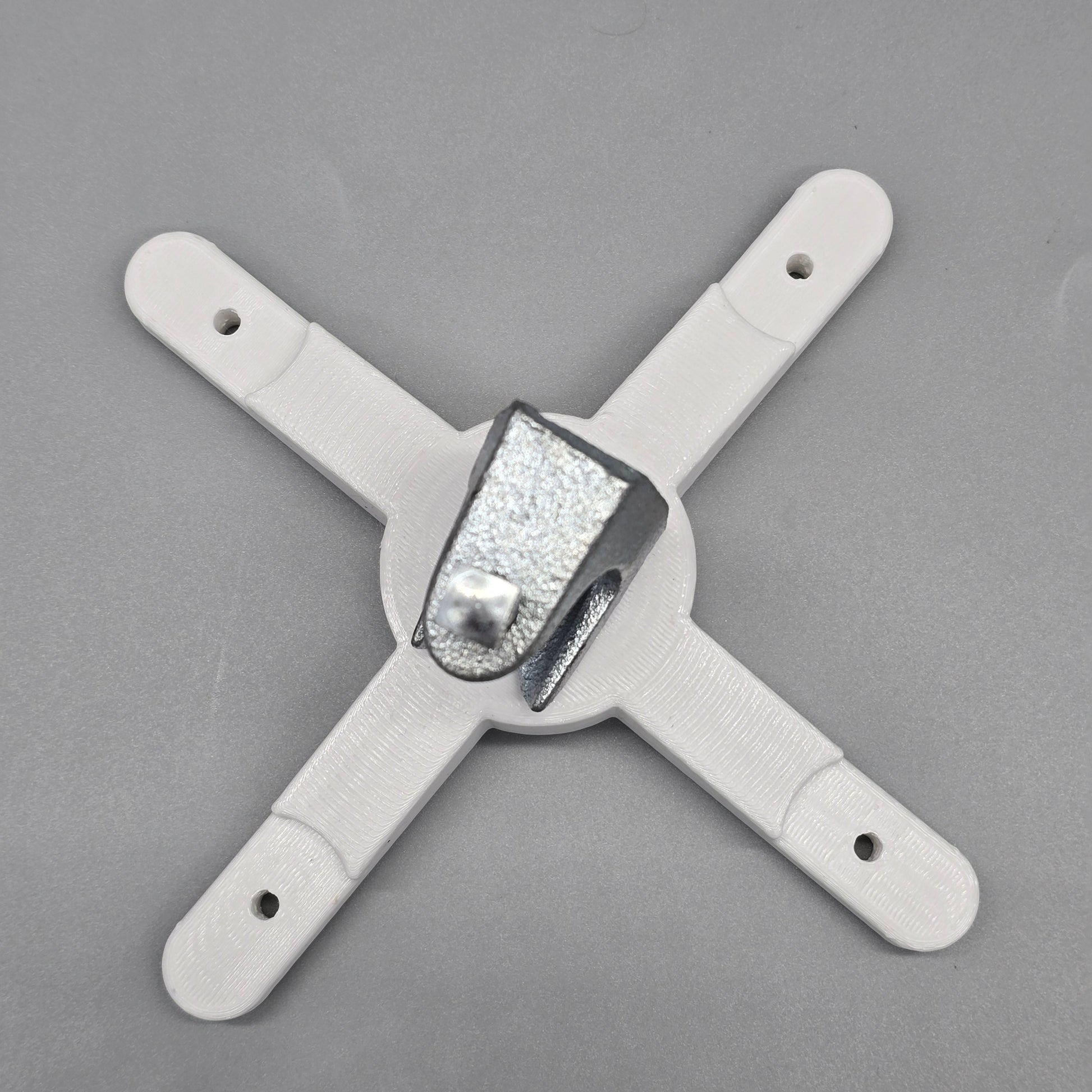 White plastic bracket with a central metallic component on a gray background